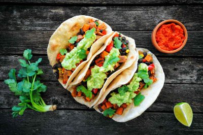 Vegan tacos with black beans, sweet potato and guacamole and tortillas flatbread